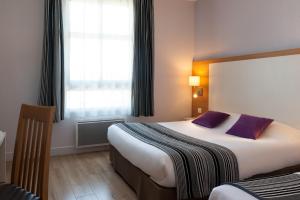 a hotel room with two beds and a window at The Originals City, Hôtel Continental, Poitiers in Poitiers