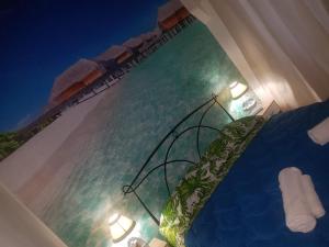 a bed with a view of the ocean with two lights at Bed Rho Stazione - Fiera in Rho