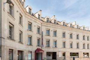 - un grand bâtiment en pierre avec un panneau dans l'établissement The Originals City, Hôtel Continental, Poitiers (Inter-Hotel), à Poitiers