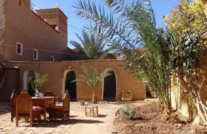 a courtyard of a building with a table and chairs at kasbah timidarte in Zaouïta Bou Lhâssane