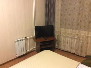 a room with two beds and a desk with a television at Apartment on Bazhenova in Zhukovsky
