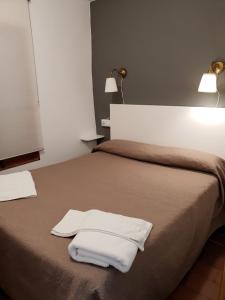 een slaapkamer met een bed met twee witte handdoeken erop bij Apartaments Can Bundanci in Setcases