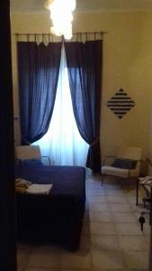 ラ・スペツィアにあるMarina's Houseのベッドルーム1室(ベッド1台、青いカーテン付きの窓付)