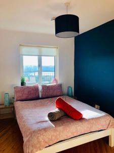 a bedroom with a large bed with a large window at Clifden Bay Apartment in Clifden