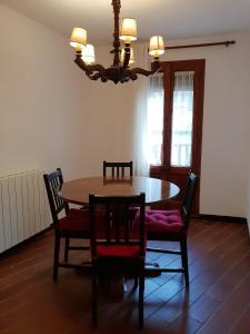 comedor con mesa, sillas y lámpara de araña en Apartaments Can Bundanci en Setcases