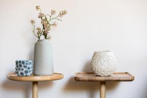 two wooden stands with vases on top of them at Hôtel La Villa Romaine in Carsac-Aillac