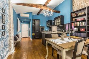 a kitchen with blue walls and a table and chairs at Delightful Carbonesi || The Place Bo Apartments in Bologna