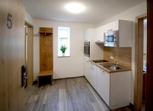 a small kitchen with white cabinets and a sink at Zur Friedenseiche in Aichach