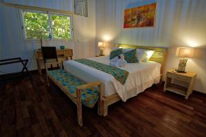 Un dormitorio con una cama, una silla y una ventana en Villa Kintana Naka, en Helville 39 fotos más