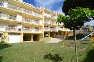 an apartment building with a playground in the yard at Riells de Mar A6 in L'Escala