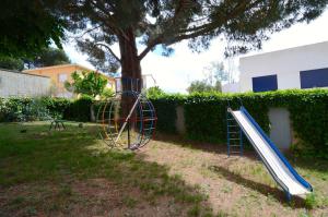 a playground with a slide next to a tree at Riells de Mar A6 in L'Escala