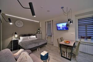 クドヴァ・ズドゥルイにあるApartamenty Sjesta Centrumのベッドルーム1室(ベッド1台付)、リビングルームが備わります。