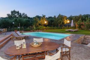 a patio with a table and chairs next to a pool at Alura Villas in Megála Khoráfia