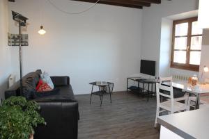 un soggiorno con divano nero e tavolo di Aritza Apartamentos Turísticos Rurales a Elizondo