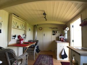 a small kitchen with a table and chairs in a tiny house at The Rowan Shepherds Hut in Eyemouth