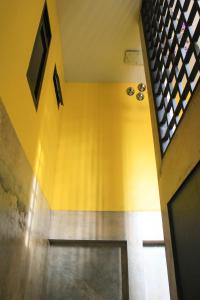 a hallway with a yellow wall and a floor at Smaids Room in Lampang