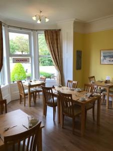 a dining room with wooden tables and chairs at West End Guest House in Elgin