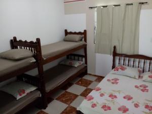 a room with two bunk beds and a window at Apartamentos Apiaí in Ilha Comprida