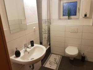 łazienka z umywalką, toaletą i oknem w obiekcie Caumanns w mieście Erkelenz