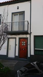 a building with a red door and a balcony at AL Visconde in Ponta Delgada