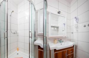 a bathroom with a shower and a sink and a mirror at Ark Beach Apartments in Split