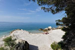 a beach with people laying on the sand and the water at Ark Beach Apartments in Split