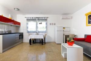 a kitchen and living room with a table and a couch at Ark Beach Apartments in Split