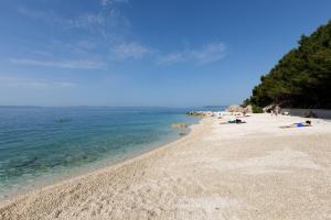 a beach with people laying on the sand and the water at Ark Beach Apartments in Split