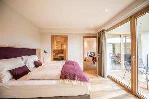 een slaapkamer met een bed en een balkon bij Dining & Living Alpenrose in Bressanone