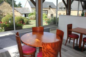 - une table et des chaises dans une chambre avec fenêtre dans l'établissement Logis Hôtel Lodge La Valette, à Cesson-Sévigné