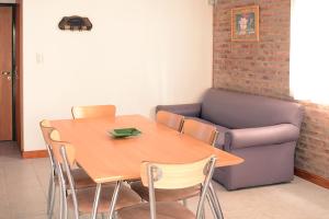 a dining room with a table and a couch at Complejo Sierras Blancas in Las Grutas