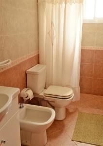 uma casa de banho com um WC e uma cortina de chuveiro em Complejo Sierras Blancas em Las Grutas