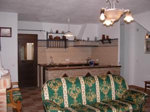 een woonkamer met een bank en een open haard bij Casas Corrales in Grazalema