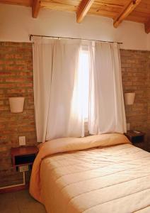 a bedroom with a large bed with a window at Complejo Sierras Blancas in Las Grutas