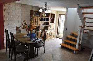 a dining room with a table with a laptop on it at Santa Elena de Maipo Home in Temuco