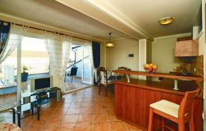 a living room with a kitchen and a television at Apartments Kristijana in Crveni Vrh