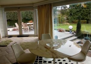 a dining room with a table and chairs and a large window at La Pastorale Brussels Expo in Wemmel