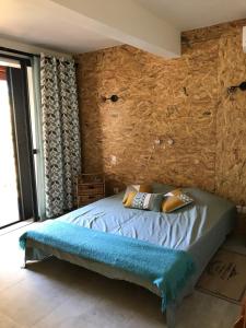 a bedroom with a bed with a stone wall at Jardin Tropical in Saint-Pierre