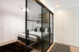 Schlafzimmer mit einem Bett und einer Glaswand in der Unterkunft Luxury for everyone - Hills Park Lux Apartments 2 in Vilnius