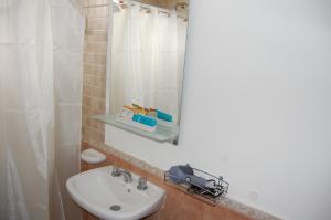 ein Badezimmer mit Waschbecken und Spiegel in der Unterkunft Aparts Casas Del Centro-El Chaltén in El Chalten + 43 Fotos