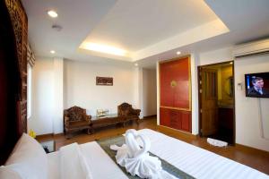 a bedroom with a bed and a tv in it at Korbua House in Bangkok