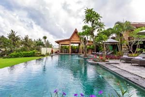 a swimming pool in front of a villa at Bali Natha Beach Front in Canggu
