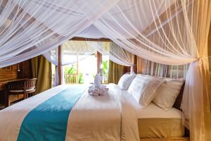 a bedroom with a white bed with a canopy at Bali Natha Beach Front in Canggu