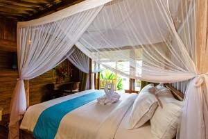 a bedroom with a white bed with a canopy at Bali Natha Beach Front in Canggu