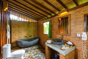 a bathroom with two sinks and a bath tub at Bali Natha Beach Front in Canggu