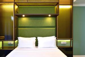 a bed with white pillows and a green headboard at My Story Hotel Augusta in Lisbon