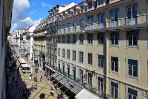 a group of people walking on a street next to a building at My Story Hotel Augusta in Lisbon