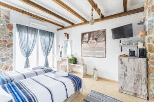 a bedroom with two beds and a flat screen tv at Limeri Traditional Guest House in Monólithos