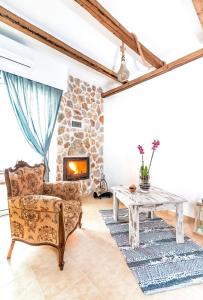 a living room with a table and a stone fireplace at Limeri Traditional Guest House in Monólithos