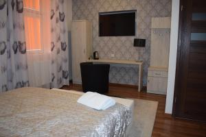 sypialnia z łóżkiem i telewizorem na ścianie w obiekcie Sepia Restauracja & Noclegi w mieście Jasło